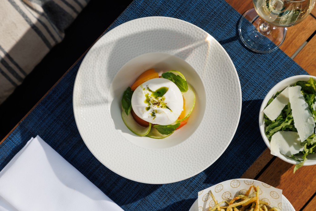 Fresh burrata with heritage tomatoes, basil and olive oil served at Azzurra Chelsea, showcasing elegant Italian coastal dining and Mediterranean cuisine in London.